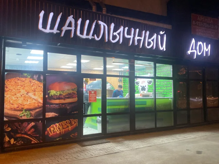Вход в Шашлычный Дом с освещённой вывеской вечером